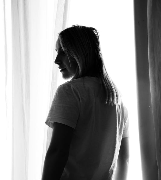 a woman standing in front of a window