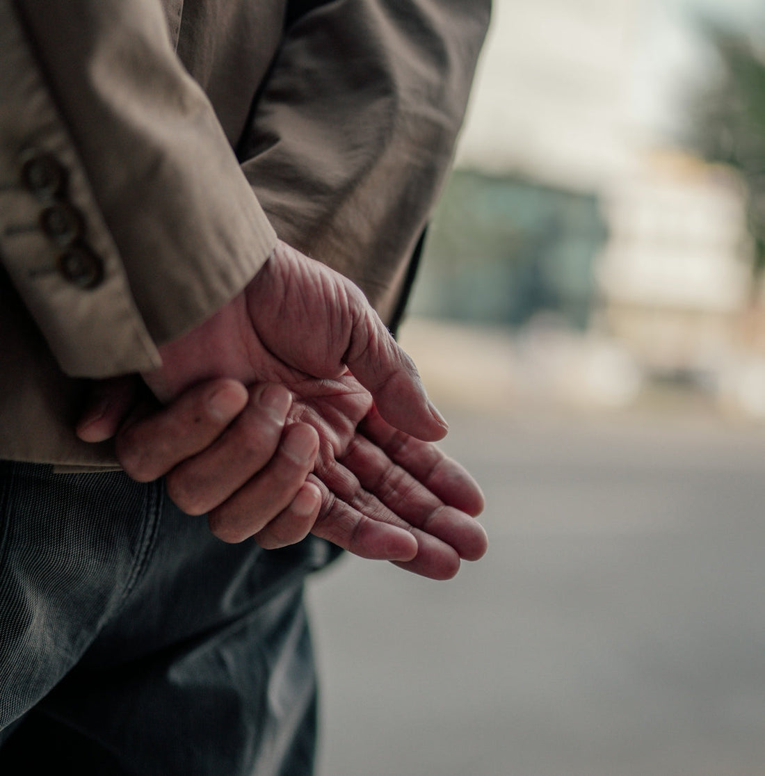 person in brown coat and black denim jeans