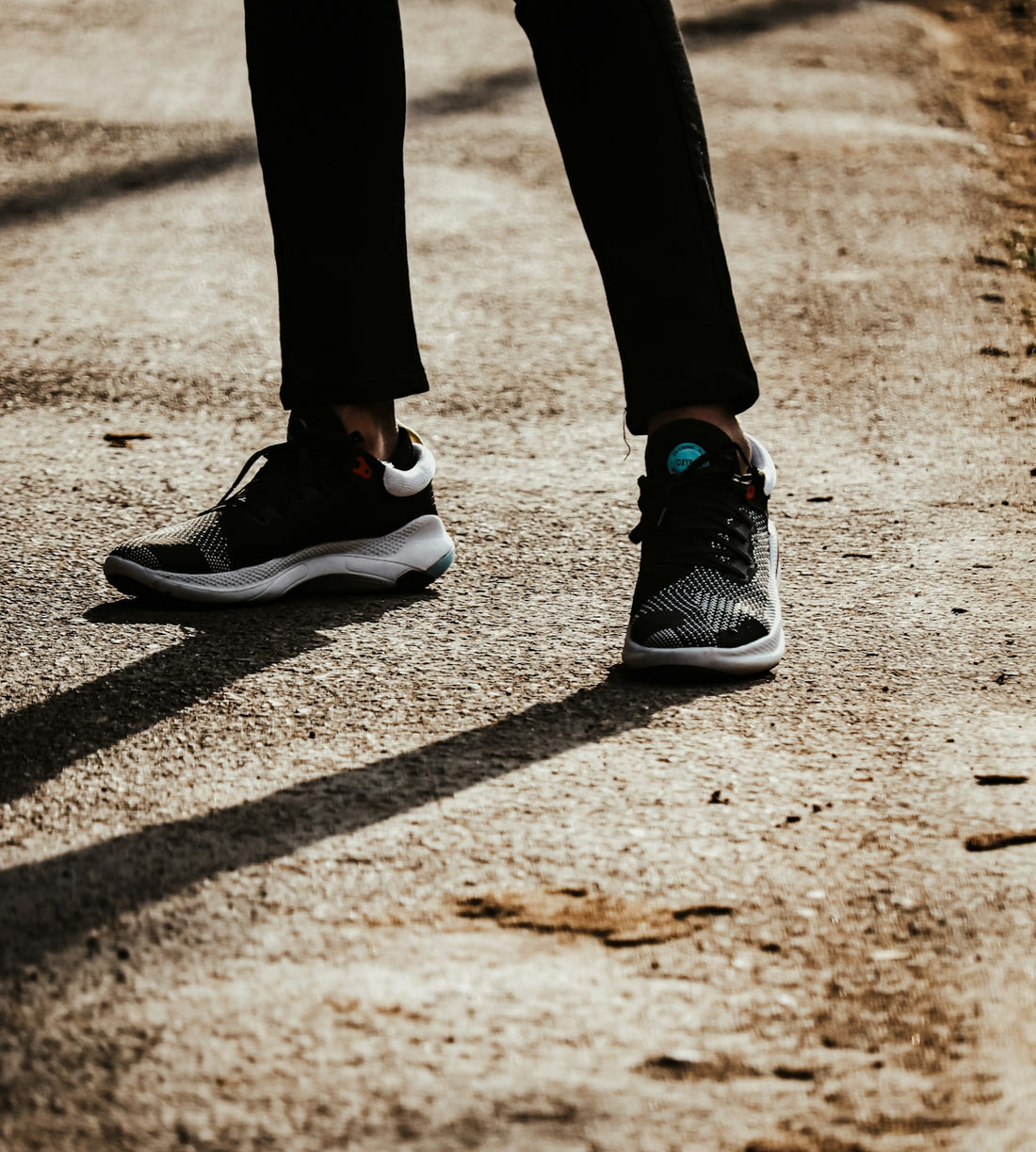 person in black pants and black and white nike sneakers
