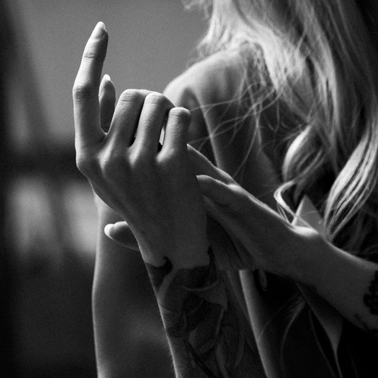 grayscale photo of woman covering her face with her hands