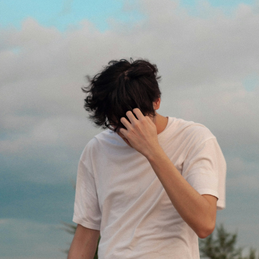 a man is covering his face with his hands