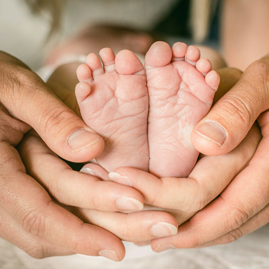 a person holding a baby's feet in their hands