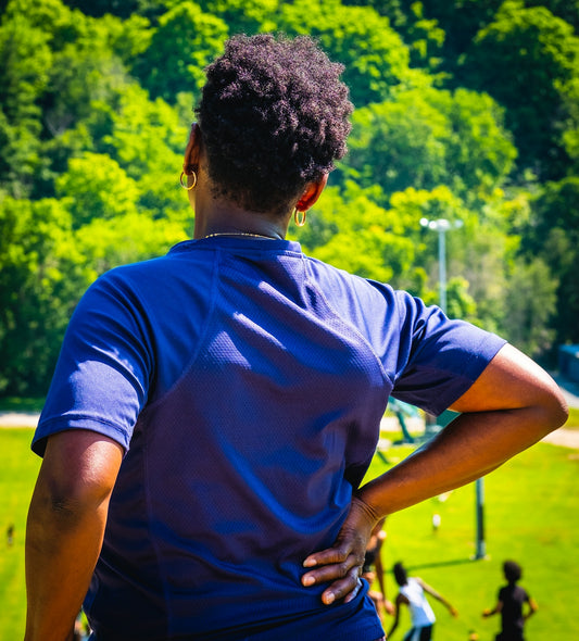 A woman standing in a park with her back to the camera