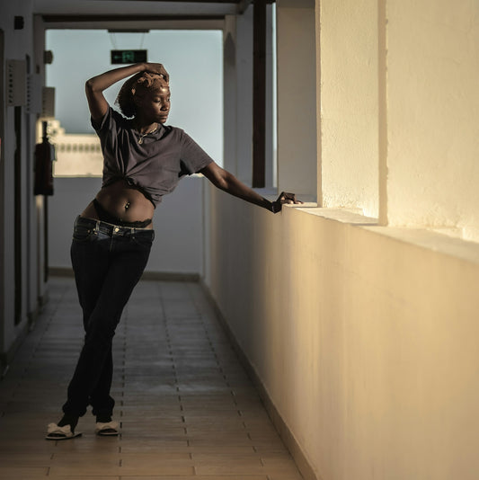 A woman leaning against a wall in a hallway