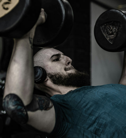 A man with a beard lifting a barbell